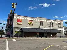 A gray corner-building with white and red trim on top