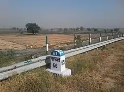 The milestone is made in front of the  way of turning entrance  into village road.