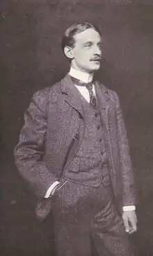 Three-quarter length portrait photograph of a man; he is wearing a three-piece suit and looking to the right.